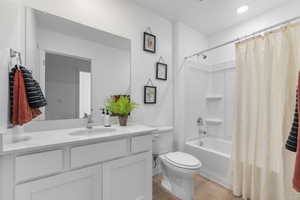 Full bathroom featuring vanity, light wood-style flooring, and shower / tub combo with curtain