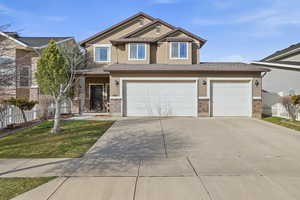 Craftsman-style house featuring stucco siding, concrete driveway, a garage, and brick siding
