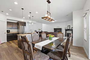 Dining room with dark wood-type flooring, a fireplace, and recessed lighting