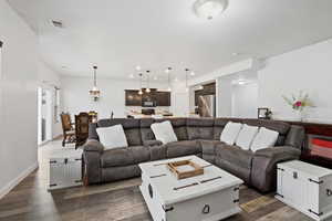 Living area featuring dark wood-type flooring and recessed lighting