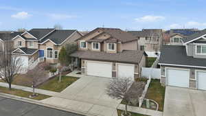 Traditional-style home featuring concrete driveway, stucco siding, a residential view, and stone siding
