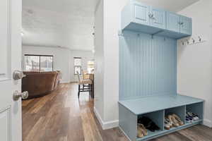Mudroom with dark wood finished floors and baseboards
