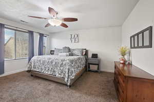Bedroom with dark colored carpet and a ceiling fan