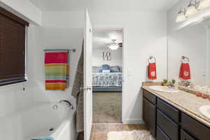 Full bath with ensuite bath, double vanity, light carpet, a bath, and light tile patterned flooring
