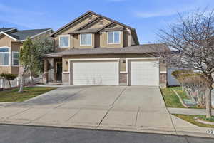 View of front of house featuring brick siding, concrete driveway, stucco siding, a garage, and covered porch