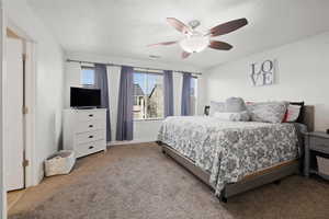 Carpeted bedroom featuring a ceiling fan and baseboards