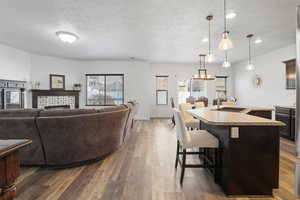 Living area with dark wood finished floors, a textured ceiling, and a tile fireplace