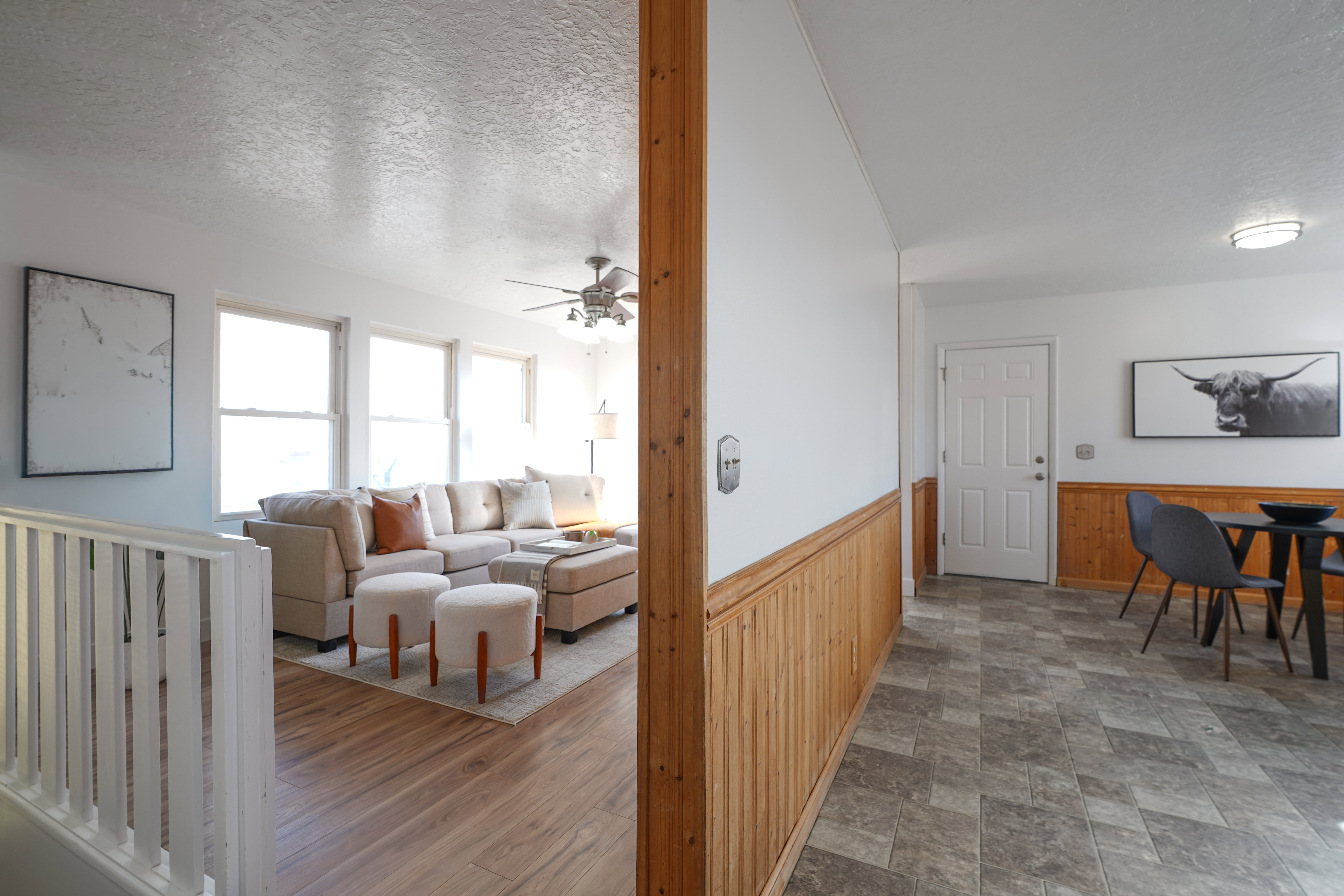 Corridor featuring a textured ceiling, a wainscoted wall, and wood walls