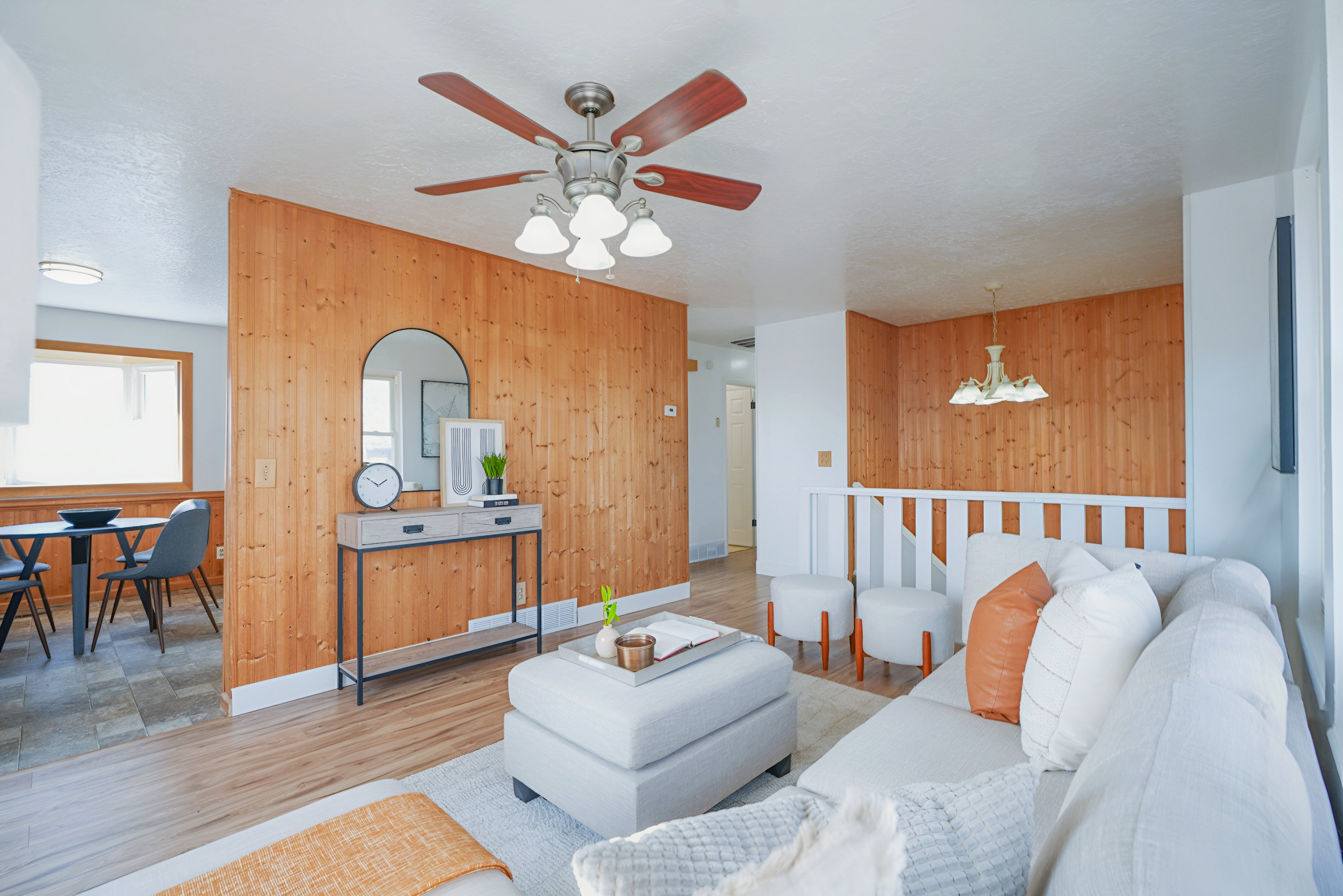 Living area with wood walls, wood finished floors, suspended lighting, and a ceiling fan