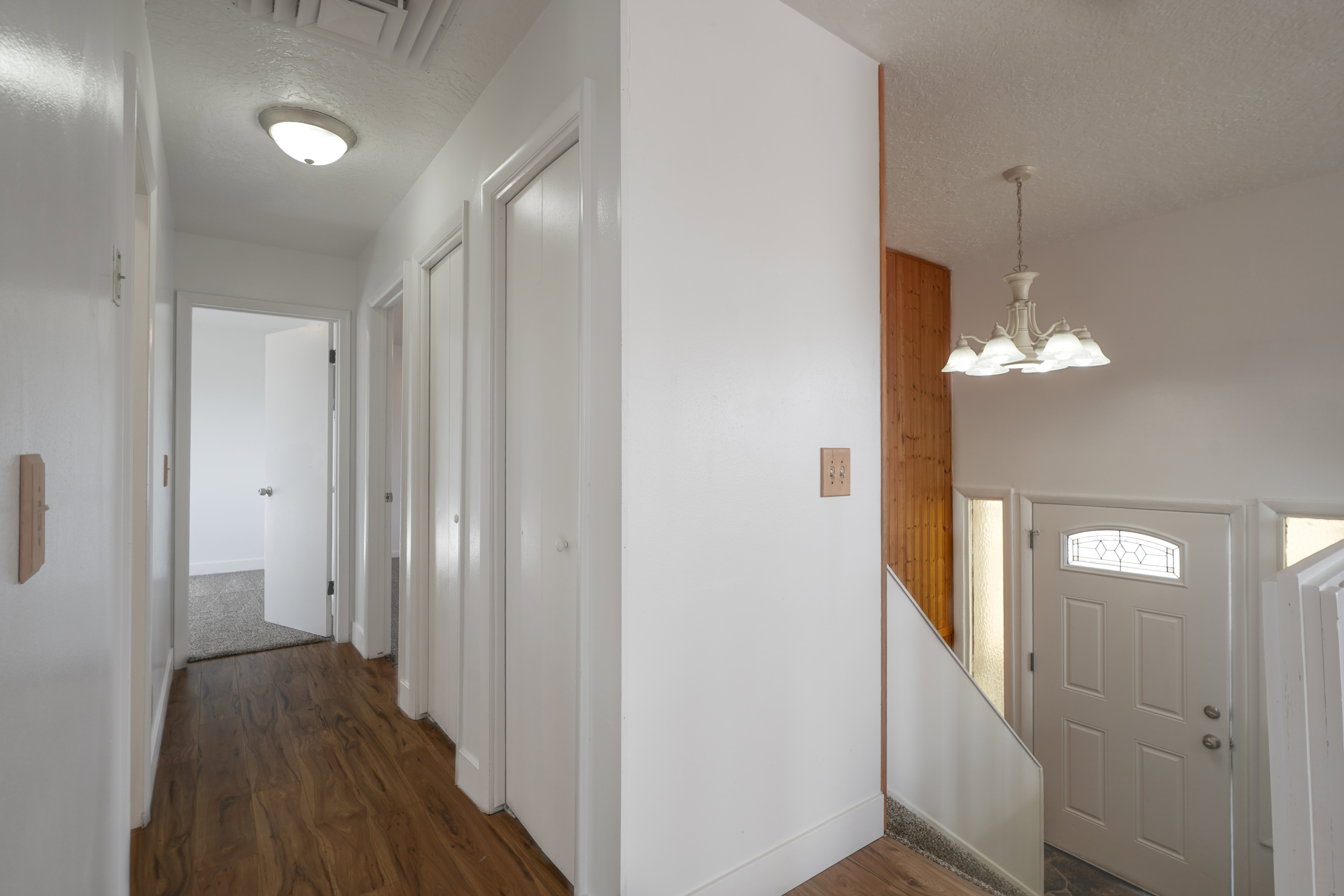 Foyer entrance with dark wood finished floors, a textured ceiling, and a chandelier