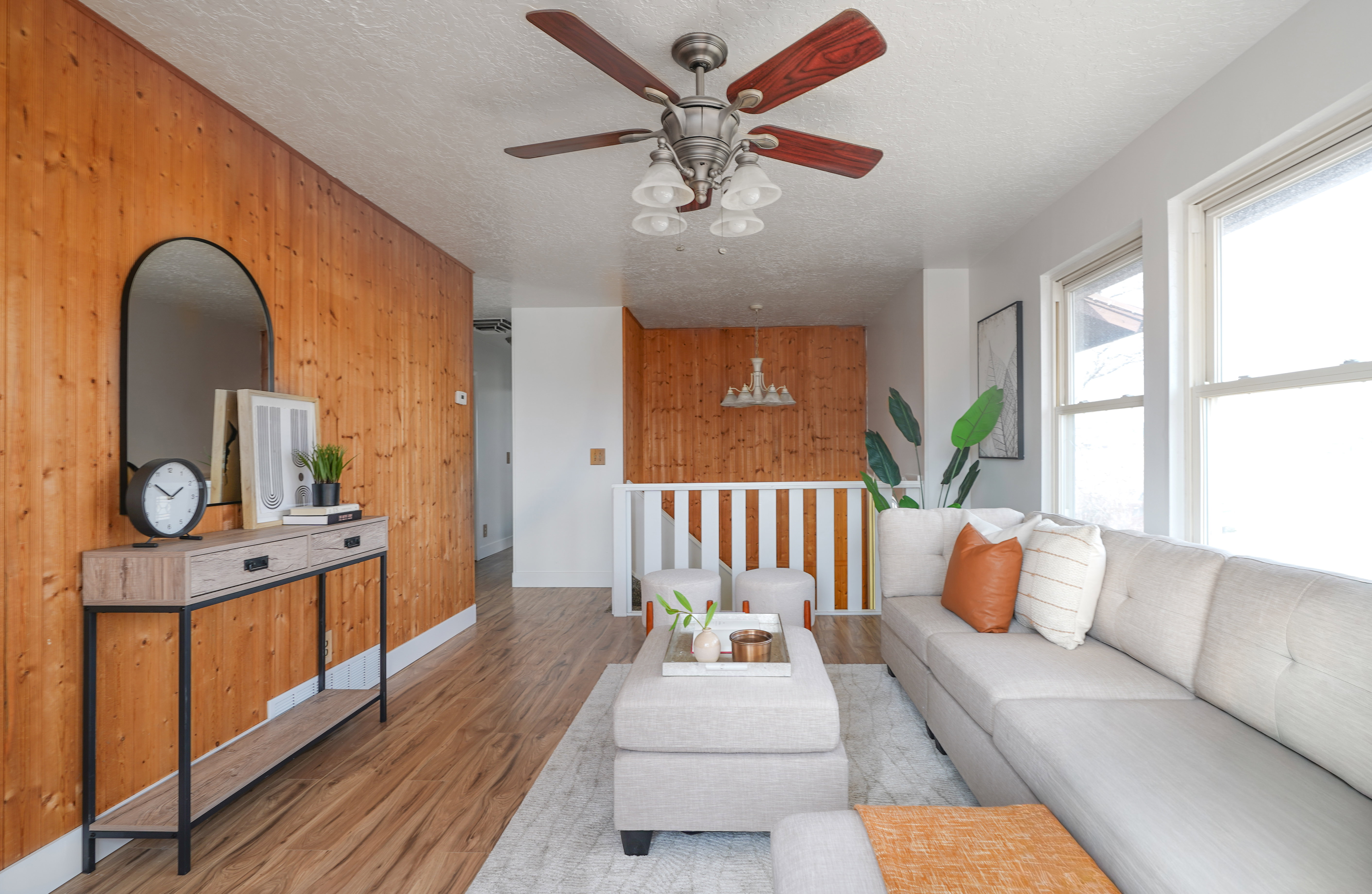Living area featuring wood walls, wood finished floors, ceiling fan, and a textured ceiling