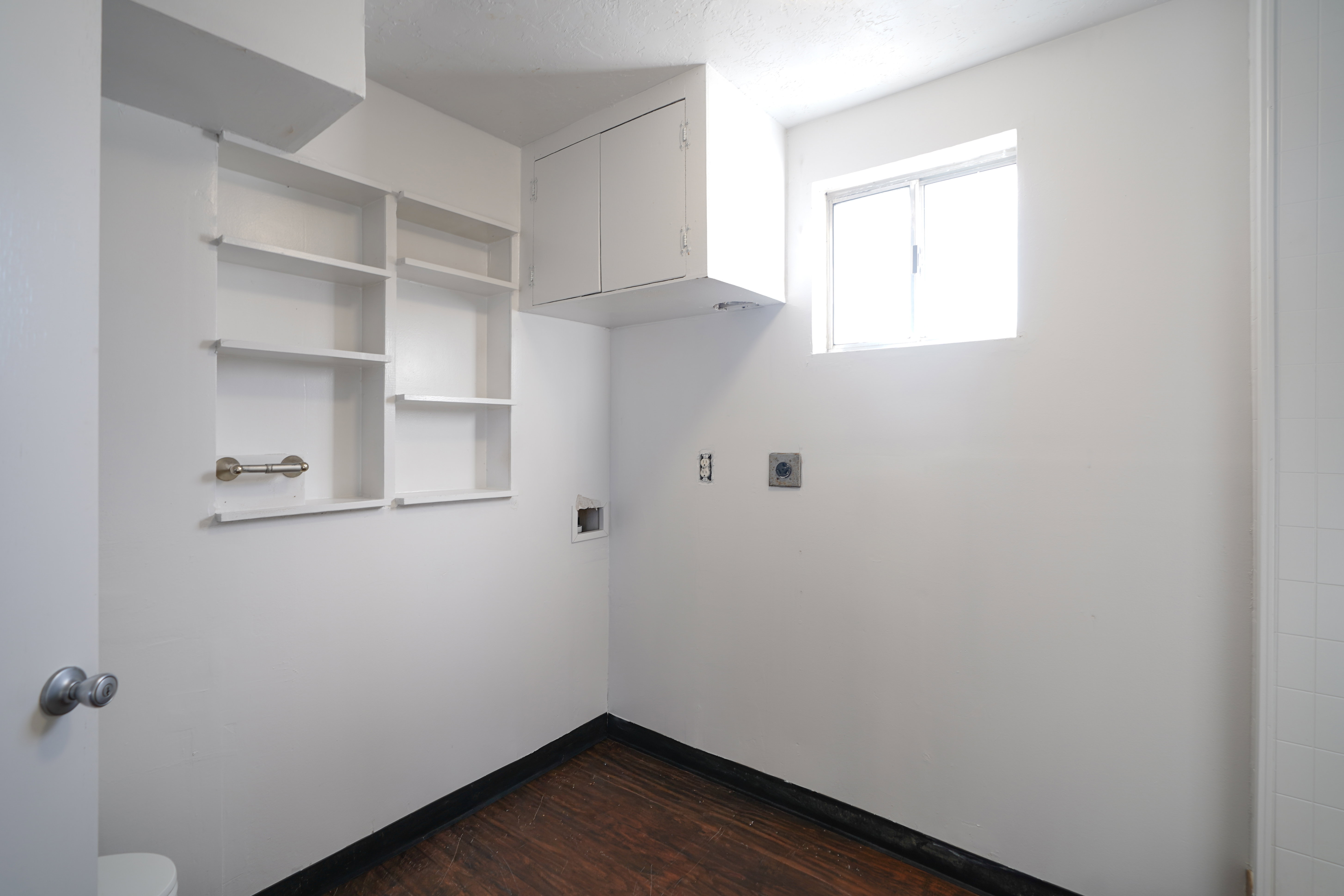 Laundry area with dark wood finished floors, cabinet space, electric dryer hookup, and washer hookup