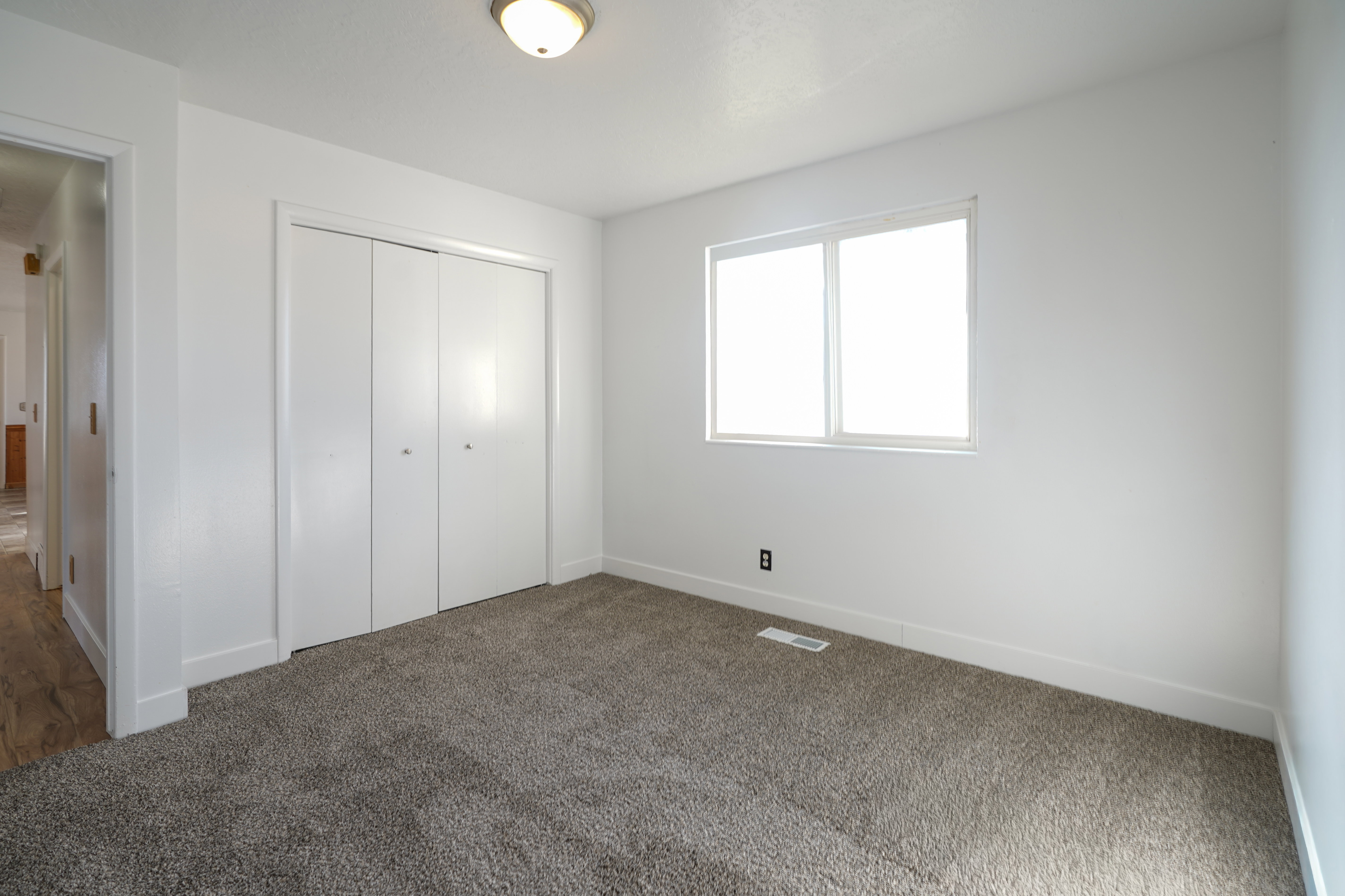 Unfurnished bedroom featuring dark carpet and a closet