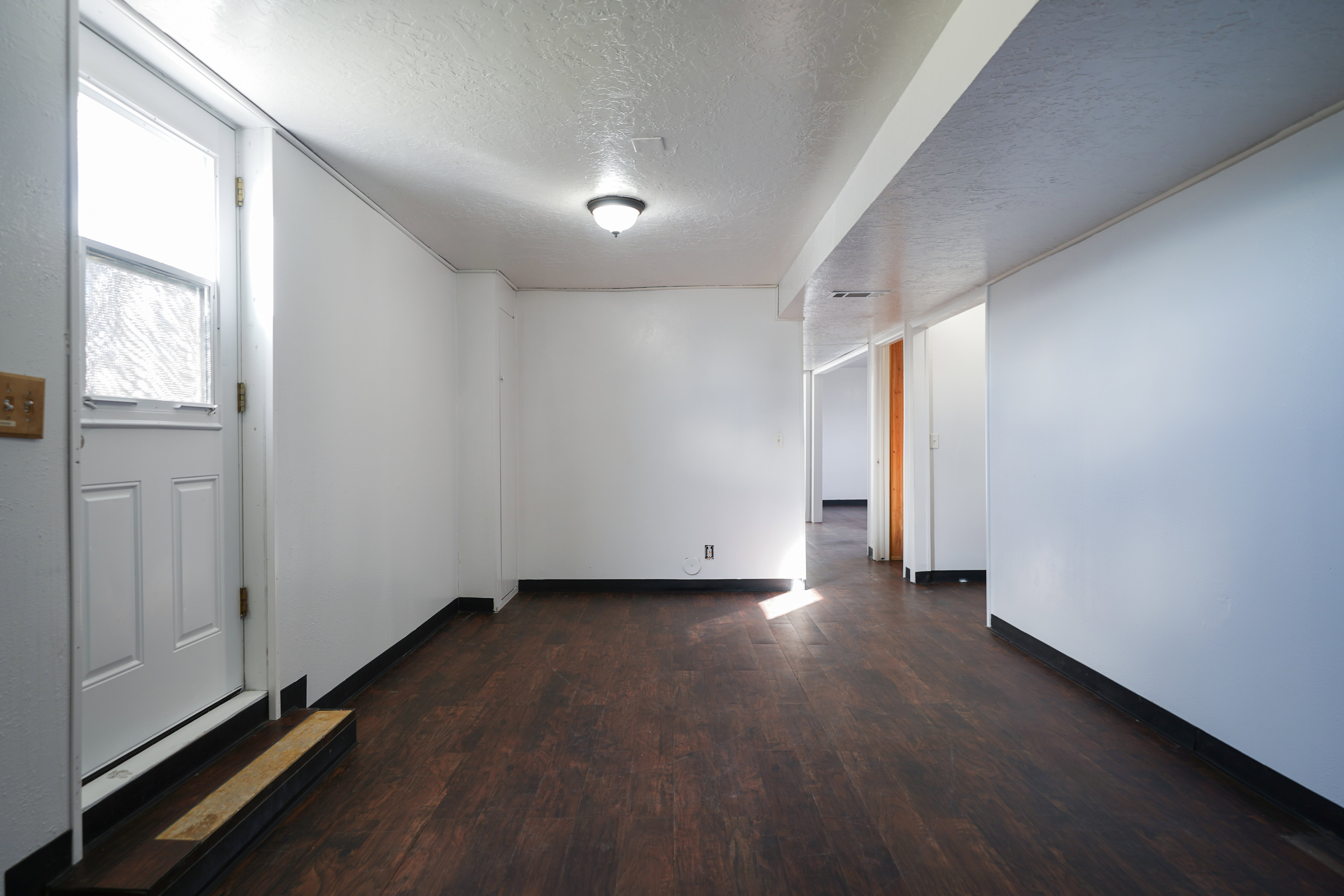 Unfurnished room featuring dark wood finished floors and a textured ceiling
