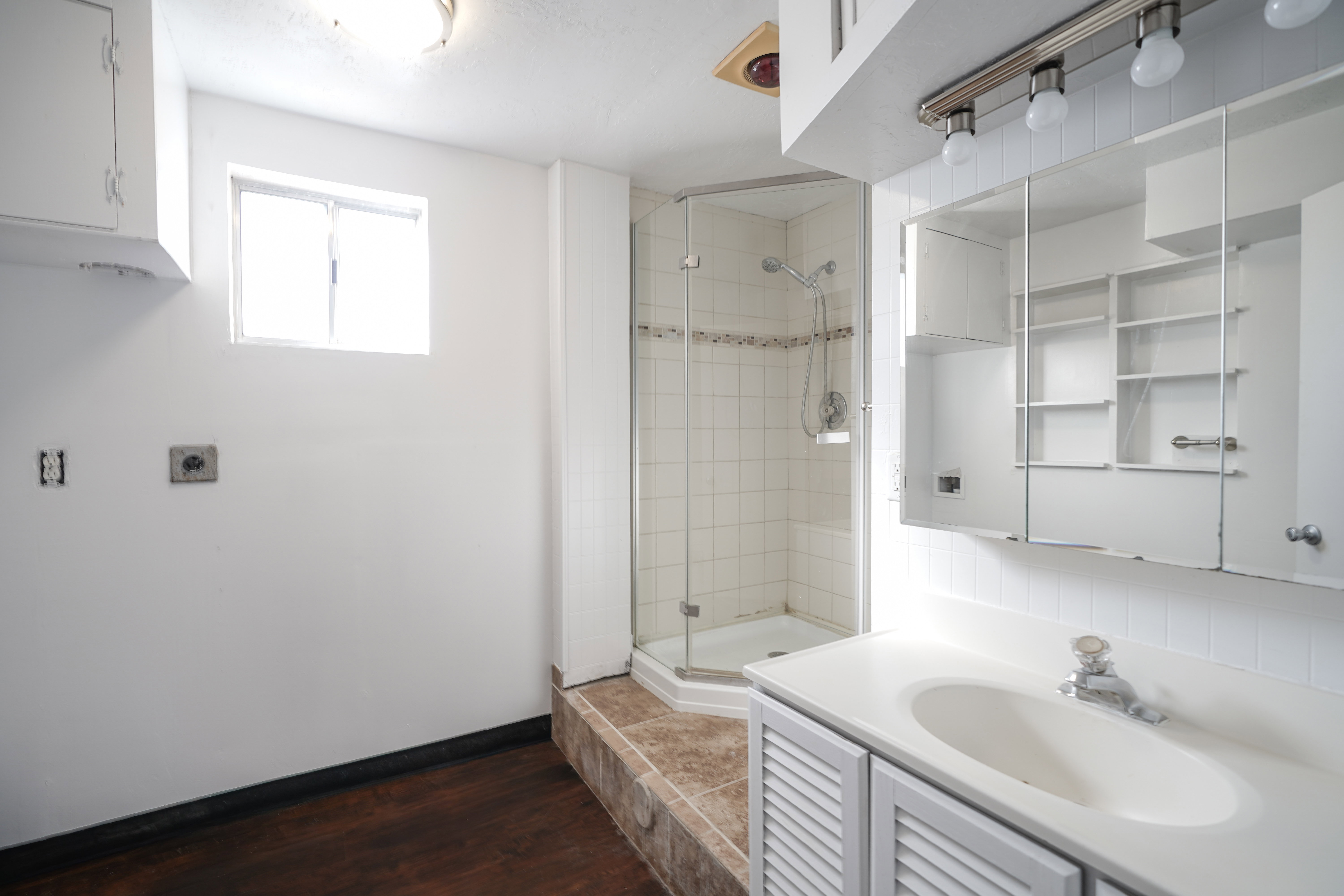 Bathroom featuring vanity, a stall shower, and dark wood finished floors