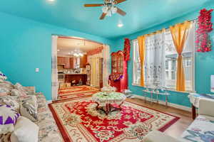 Living area featuring a ceiling fan, light wood-type flooring, and hanging lights