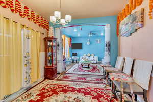 Living area featuring suspended lighting and a ceiling fan