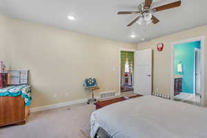 Bedroom with light carpet, ceiling fan, recessed lighting, and ensuite bathroom