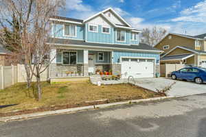 Craftsman-style house featuring board and batten siding, a porch, driveway, stone siding, and a garage