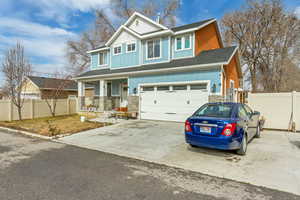 Craftsman house with board and batten siding, concrete driveway, stone siding, covered porch, and a garage