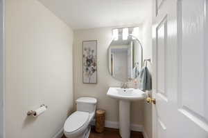 Bathroom with toilet and wood finished floors