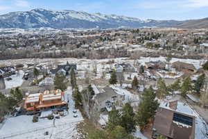 Snowy aerial view featuring a mountain view and a residential view