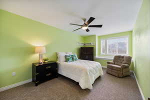Bedroom featuring dark carpet and ceiling fan