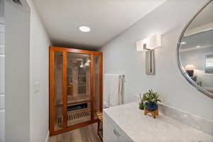 Bathroom featuring a sauna / steam room, vanity, and dark wood-type flooring