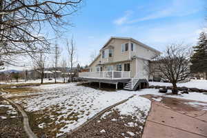 Snow covered property with a deck and stairway