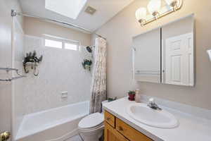 Full bathroom featuring vanity, shower / bath combo, and a skylight
