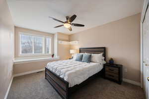 Bedroom featuring ceiling fan and dark colored carpet