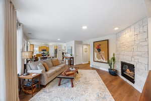 Living room featuring a fireplace, light wood-style floors, and recessed lighting