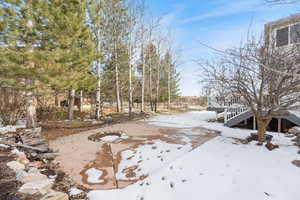 Snowy yard featuring a patio