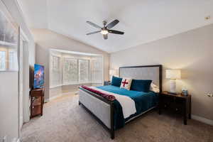 Bedroom featuring lofted ceiling, carpet, and a ceiling fan