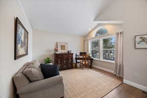 Living area featuring an office area, wood finished floors, lofted ceiling, and recessed lighting