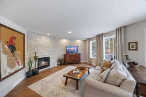 Living room featuring wood finished floors, a fireplace, and recessed lighting