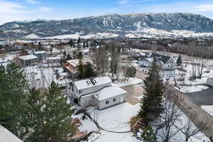 Snowy aerial view with a mountain view and a residential view