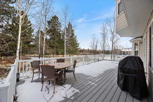 Snow covered deck with grilling area and outdoor dining area