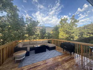 Wooden terrace with grilling area and an outdoor living space with a fire pit