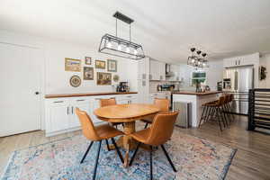 Dining room featuring light wood-style flooring and a chandelier