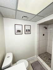 Full bathroom featuring a stall shower and a drop ceiling