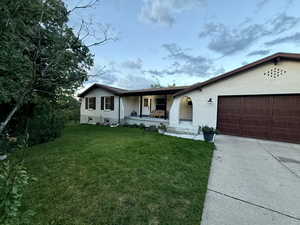 Ranch-style house featuring covered porch, a front lawn, a garage, brick siding, and concrete driveway