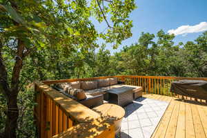 Deck with outdoor seating and view of scattered trees