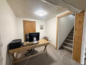 Office space featuring light colored carpet and wood ceiling