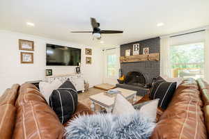 Living room featuring wood finished floors, a fireplace, ceiling fan, wood walls, and recessed lighting