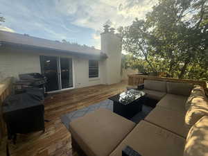Wooden terrace with an outdoor living space with a fire pit and a grill