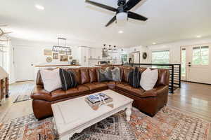 Living room with light wood-type flooring, recessed lighting, and a ceiling fan