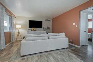 Living room with wood finished floors and a textured ceiling