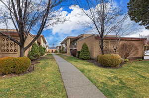 View of side of home with a yard, a residential view, and brick siding