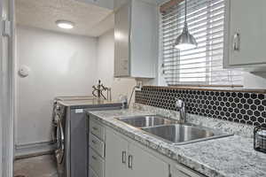 Laundry room featuring a textured ceiling and independent washer and dryer